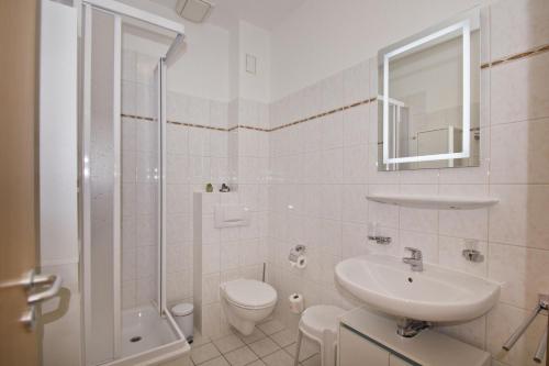 a bathroom with a sink and a toilet and a shower at Haus Brandenburg FeWo 37 - strandnah in Göhren