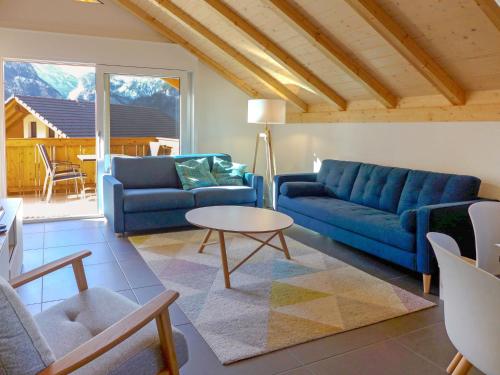 a living room with a blue couch and a table at Apartment Momento by Interhome in Kandersteg