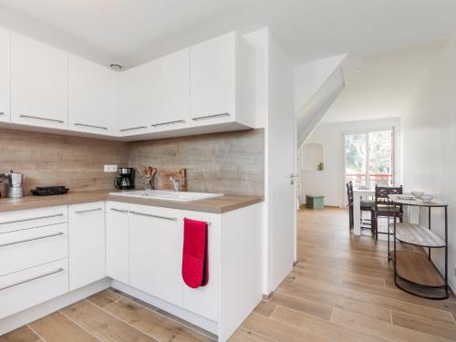 una cocina con armarios blancos y una toalla roja en Apartment La Cité du Lac-4 by Interhome en San Juan de Luz