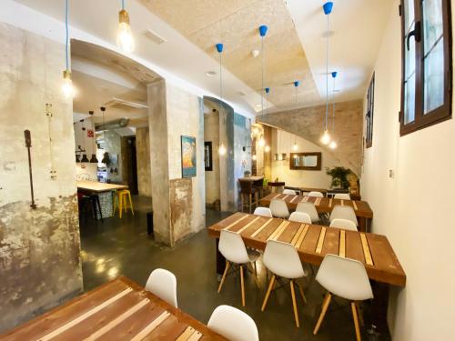 a dining room with wooden tables and white chairs at ECO Hostel in Granada