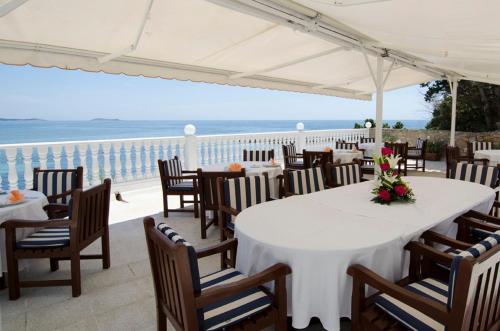 a restaurant with tables and chairs and a view of the ocean at Grand Hotel Palladium Santa Eulalia del Río in Santa Eularia des Riu