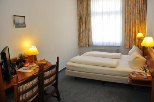 a hotel room with a bed and a desk with a computer at Brocki's Hotel Stadt Hamburg in Parchim