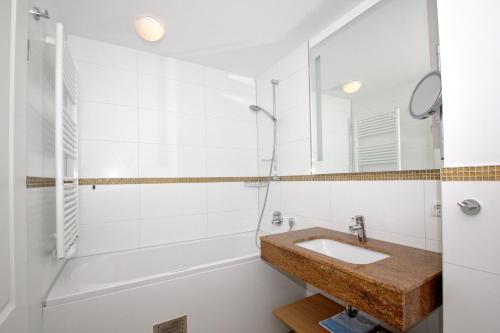 ein Badezimmer mit Waschbecken und Badewanne in der Unterkunft strandnahe FeWo mit Balkon, gratis Nutzung vom AHOI Erlebnisbad und Sauna in Sellin - Rex Rugia FeWo 30-6 in Lobbe