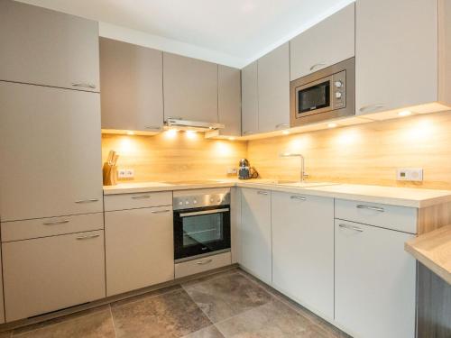 a kitchen with white cabinets and a microwave at Apartment Aileen by Interhome in Fliess