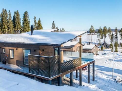 a house with a deck in the snow at Holiday Home Viherlaakso a by Interhome in Tahkovuori