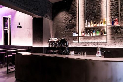 a bar in a restaurant with a counter with bottles at Heart Hotel Milano in Milan