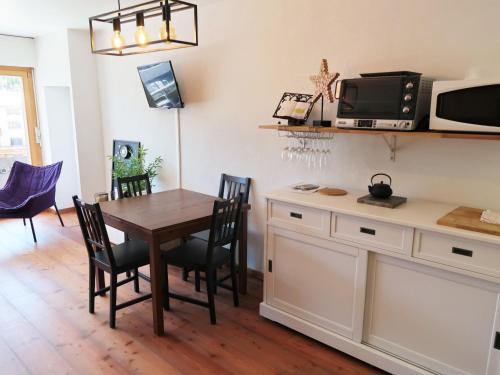 eine Küche und ein Esszimmer mit einem Tisch und Stühlen in der Unterkunft Studio Bouleaux B1 by Interhome in Nendaz