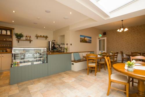 a restaurant with a table and chairs and a counter at Cul-Erg House & Kitchen in Portstewart