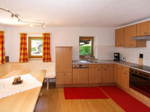 een keuken met houten kasten en een rood tapijt bij Holiday Home Wierer-2 by Interhome in Fügen