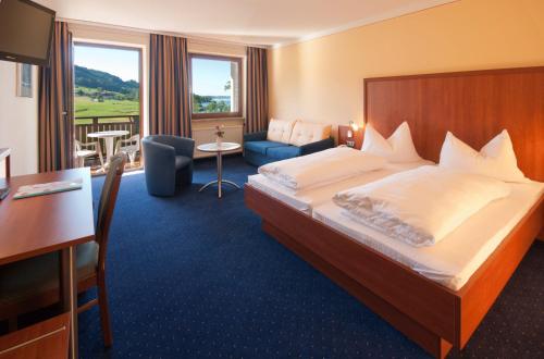ein Hotelzimmer mit einem großen Bett und einem Schreibtisch in der Unterkunft Seehotel Garni Pöllmann in Mondsee