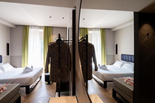 a hotel room with two beds and a mirror at Heart Hotel Milano in Milan