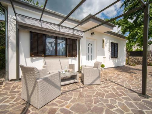 eine Terrasse mit Stühlen und einem Tisch vor einem Haus in der Unterkunft Holiday Home Erminia by Interhome in Lovran