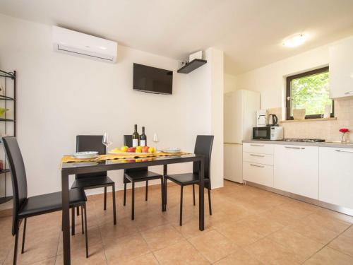 eine Küche und ein Esszimmer mit einem Tisch und Stühlen in der Unterkunft Holiday Home Erminia by Interhome in Lovran