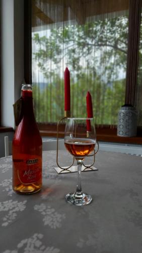 a bottle of alcohol and a wine glass on a table at CASA DINCA in Cîmpu lui Neag