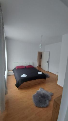 a bedroom with a black bed with a furry rug at CASA DINCA in Cîmpu lui Neag