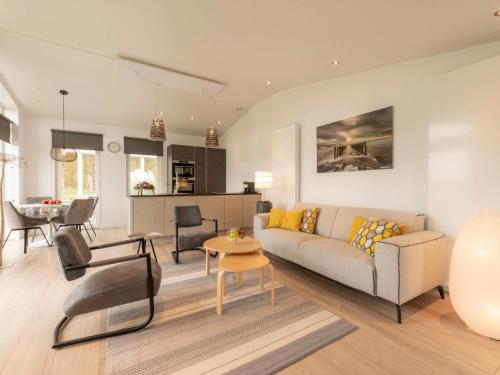 een woonkamer met een bank en een tafel bij Holiday Home Ruisweg 89 by Interhome in Wemeldinge
