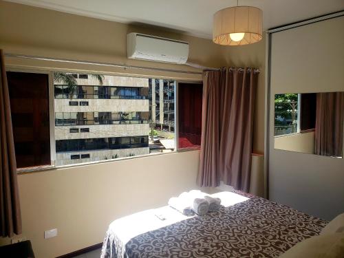 マセイオにあるExcelente Apartamento Maceióのベッドと景色の見える窓のある寝室