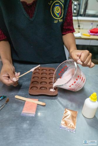 a person is making a chocolate cake on a counter at La Posada Del Arte in Baños
