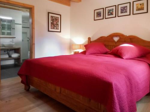 ein Schlafzimmer mit einem großen Bett mit einer roten Decke in der Unterkunft Chalet Banksia by Interhome in Ovronnaz