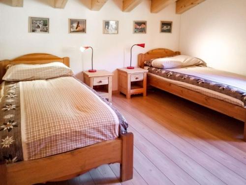 two beds in a room with two lamps on tables at Chalet Banksia by Interhome in Ovronnaz