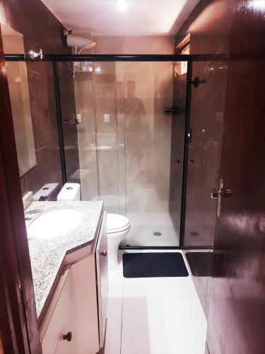 a bathroom with a shower with a toilet and a sink at Excelente Apartamento Maceió in Maceió