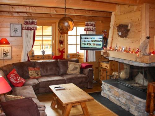 uma sala de estar com um sofá e uma lareira em Chalet Dörfli by Interhome em Les Diablerets