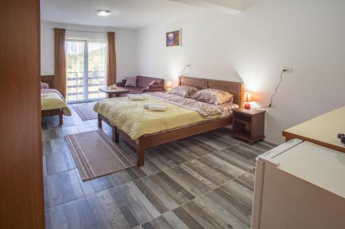 a bedroom with a bed and a living room at Apartmani JEZERO in Žabljak