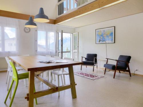 ein Esszimmer mit einem Holztisch und Stühlen in der Unterkunft Apartment Belvedere by Interhome in Brienz