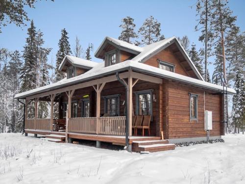 eine Blockhütte im Schnee im Wald in der Unterkunft Holiday Home Kiehtäjän virta by Interhome in Käylä