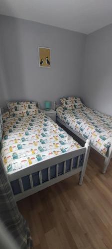 2 Betten nebeneinander in einem Zimmer in der Unterkunft Knockalt Cottage in Moville