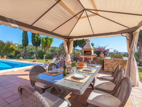 a patio with a table and chairs with an umbrella at Villa Villa Rosa by Interhome in Loulé