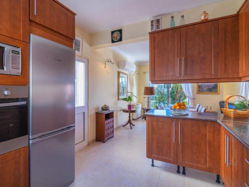 a kitchen with wooden cabinets and a stainless steel refrigerator at Villa Villa Rosa by Interhome in Loulé