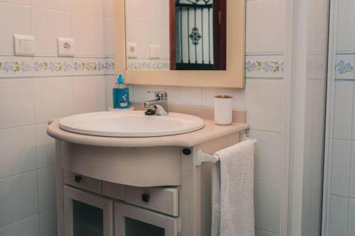 un baño con lavabo y espejo en Casa Pepita Feria, en Valverde del Camino