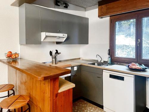 cocina con encimera de madera y fregadero en Apartment Lisière-Sud by Interhome en Crans-Montana
