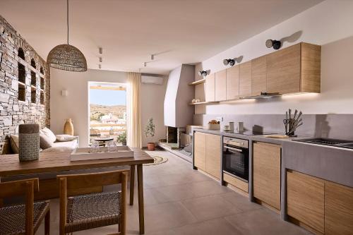 una cocina con armarios de madera y una mesa en una habitación en Syllac Elegant Stay, en Dhriopís