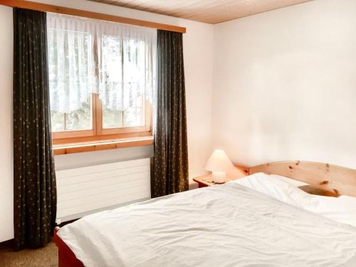 a bedroom with a white bed and a window at Apartment Haus Lotti Apt 203 by Interhome in Schmitten