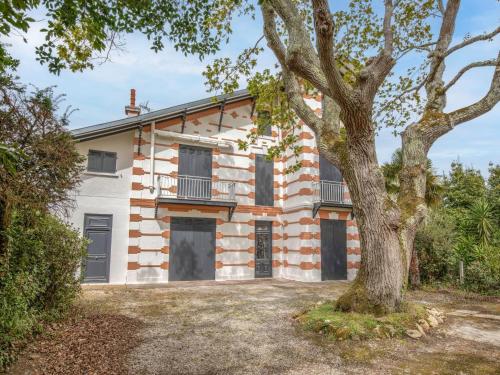 une maison en briques avec un arbre devant elle dans l'établissement Apartment Durandal by Interhome, à Arcachon