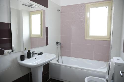 een badkamer met een wastafel, een bad en een wastafel bij Square View Apartment in Vlorë
