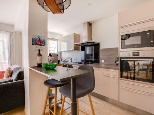 une cuisine avec une table et des chaises dans une pièce dans l'établissement Apartment Calliope by Interhome, à Arcachon