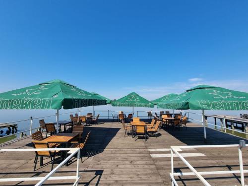 a group of tables and chairs with umbrellas on a pier at ElGringo Clisura Dunarii in Moldova Nouă