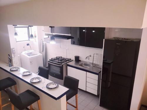 マセイオにあるExcelente Apartamento Maceióのキッチン(黒い冷蔵庫、テーブル、椅子付)
