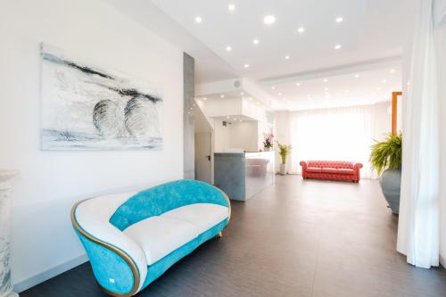 a living room with a blue and white chair at Park Hotel Giusy in Lido di Camaiore