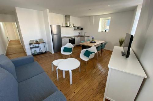 un salon avec un canapé bleu et une table dans l'établissement George V - Enjoy the view of the sea channel, à Les Sables-dʼOlonne