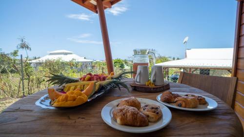 un tavolo con piatti di pane e frutta di KARUKERA - Les Villas KIKKO a Sèze