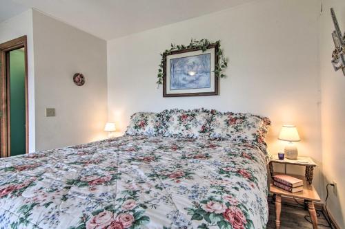 a bedroom with a bed with a floral bedspread at Chincoteague Townhome with Pony Views from Deck! in Chincoteague