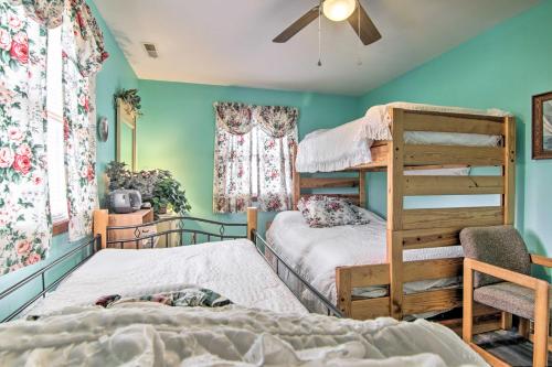 a bedroom with two bunk beds and a ceiling fan at Chincoteague Townhome with Pony Views from Deck! in Chincoteague