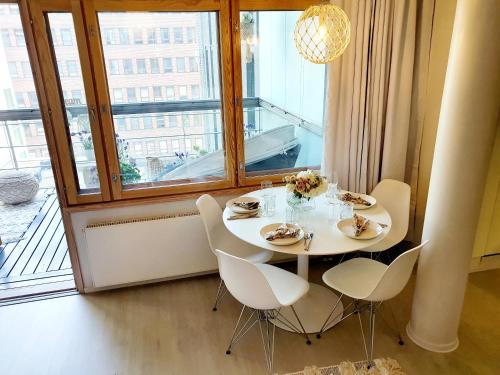 a dining room with a table and chairs and a window at 2ndhomes Unique and Luxury Kamppi Center Apartment with Sauna and Big Terrace in Helsinki