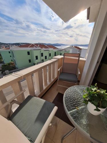 a balcony with a table and chairs and a view at Apartmani Levarda in Trogir