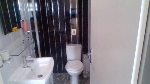 a bathroom with a white toilet and a sink at Kings Boutique Hotel in Blackpool