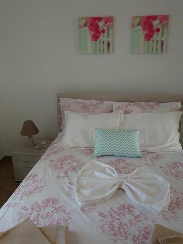 a bed with a white dress and a bow on it at Annezina's memories in Logaras